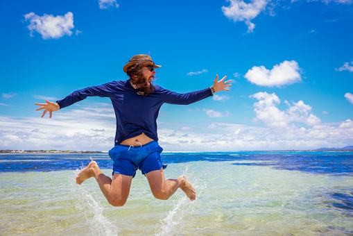 A man in Mauritius jumps into the ocean, captured mid-air.