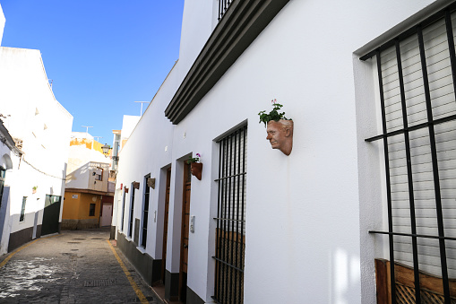 Rota, Cadiz, Spain- October 10, 2023: Street with Personalized flower pots with the face of neighbors made by the artist Julio Malvido