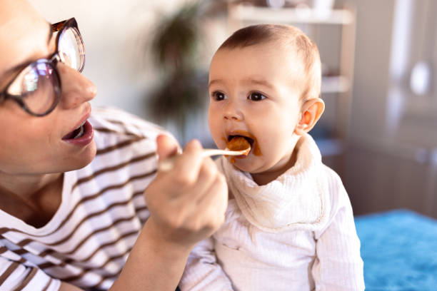 istock Mother feeding her messy baby at home 1974922575