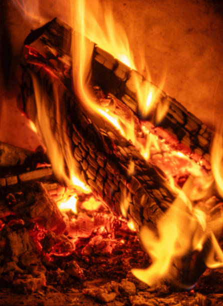 Close-up of burning wood, fireplace, fire. Vertical. Selective focus.