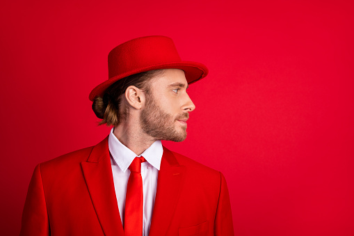 Photo portrait of attractive young man look empty space profile wear trendy classic clothes isolated on red color background.