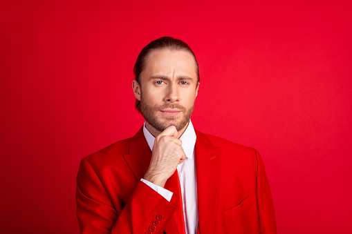Photo portrait of elegant young male touch chin serious thoughtful wear trendy classic garment isolated on red color background.