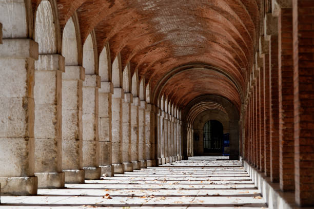 White concrete pillars and brick arches line arched passageways