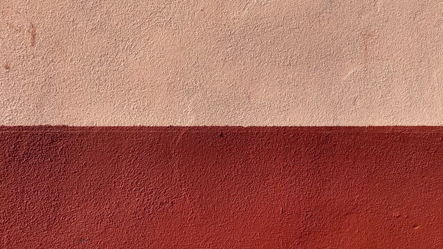 Concrete wall painted in pink and red colors