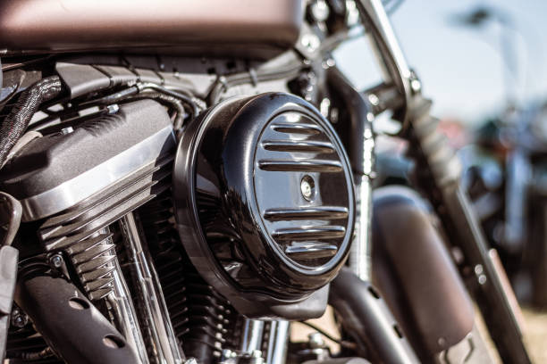 Detailed shot highlighting the polished chrome engine components and exhaust pipes of a vintage motorcycle, emphasizing its intricate mechanical craftsmanship and shiny metallic finish.