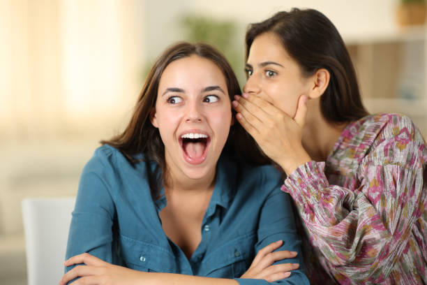 mujer contando un secreto increíble a un amigo - whispering couple discussion smiling fotografías e imágenes de stock