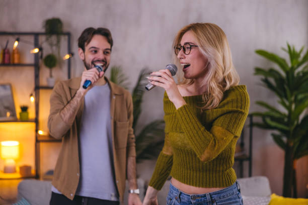 istock Two young friends having fun together while singing and dancing 1974994518