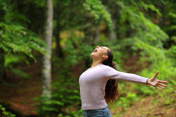 istock Happy woman screaming alone in nature 1974995044