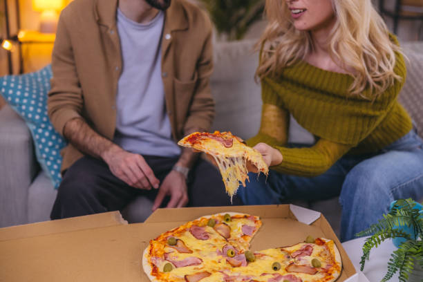 istock Two friends sharing a pizza at home 1974997144