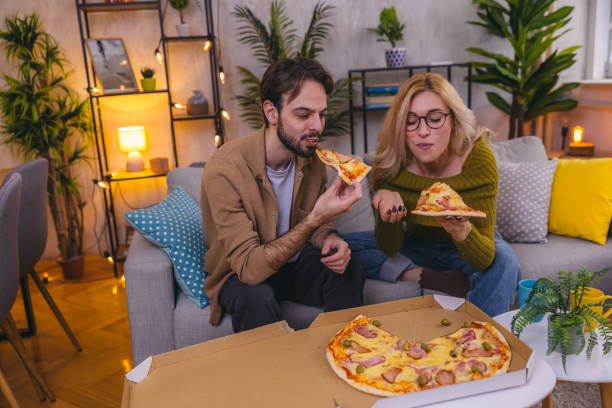 istock Two friends sharing a pizza at home 1974997655