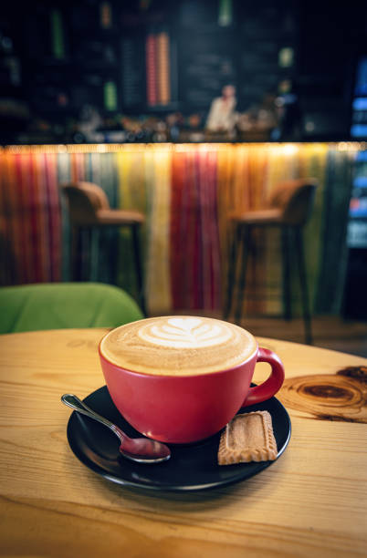 Cup of hot cappuccino coffee on table