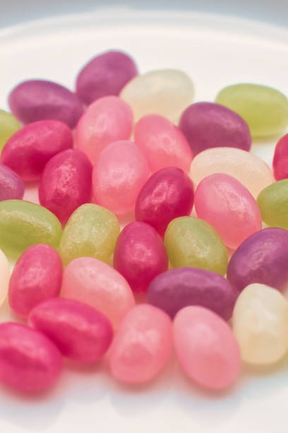 Studio shot of a cute young girl holding a handful of colorful jelly beans