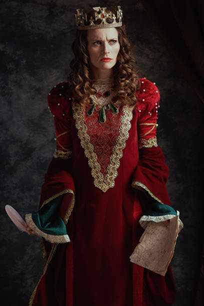 istock furious medieval queen in red dress with parchment and crown 1975060205