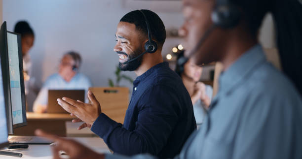 istock Business man, call center and computer for night customer service, e commerce support and happy helping in office. Professional consultant or agent for website solution, questions or FAQ in workspace 1975060819