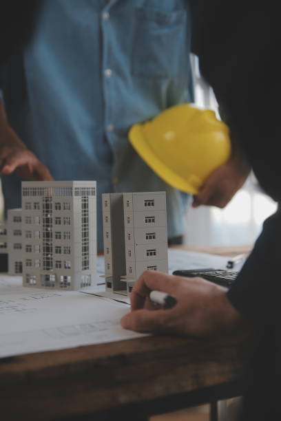 istock Construction and structure concept of Engineer or architect meeting for project working with partner and engineering tools on model building and blueprint in working site, contract for both companies. 1975062567