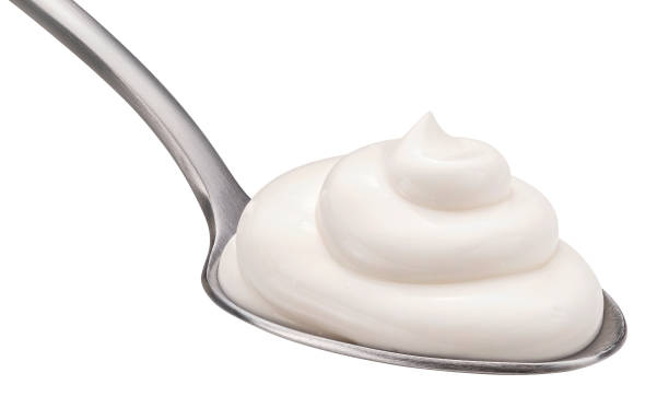 istock Sour cream in spoon isolated on white background 1975069480