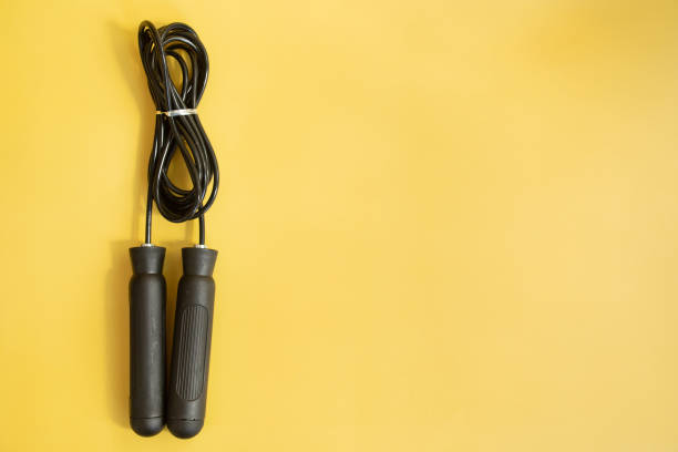 Black skipping rope isolated on yellow background