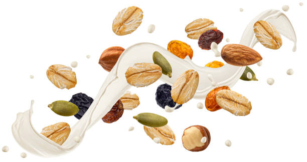 Falling muesli, oat granola with milk splash isolated on white background