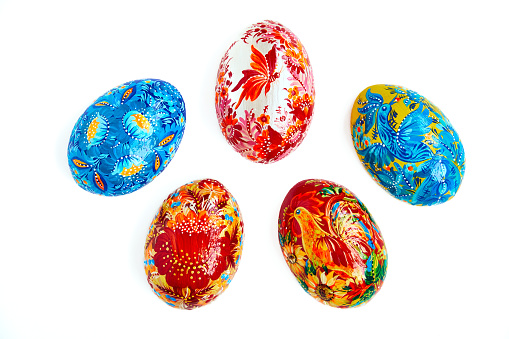 Colored Easter eggs on black plate on wooden background