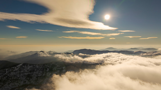 Aerial view through clouds above mountains