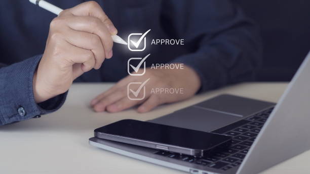 istock Businessman hand with pen to correct sign symbol mark on approve box for document approval 1975159918