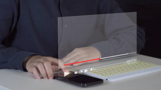 istock man using mouse and keyboard for streaming online on virtual screen, watching video on internet, live concert, show or tutorial, content online 1975161998
