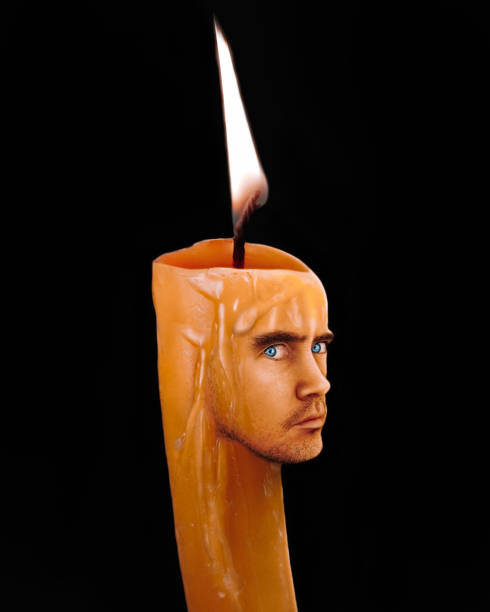 Candle with a human face on a black background. Candle man isolated, artistic character.
