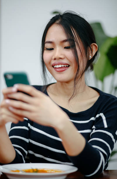 istock Young Smiling Woman Using Mobile Phone At Home. 1975216989