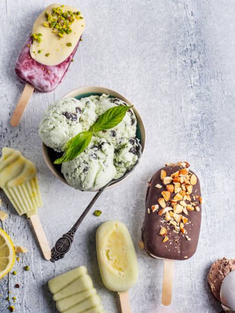 Various colorful ice cream sorts with fruits in bowl, stick. Stick ice cream. Chocolate almonds with banana Ice cream bar. Lemon and avocado Ice Cream Pops.  Ice cream bar with white chocolate and berry. Large collection of ice cream and lollies.