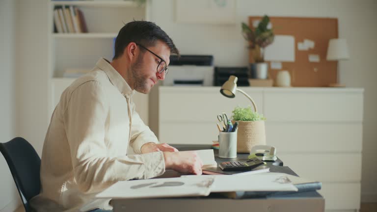 Exhausted businessman preparing reports at office