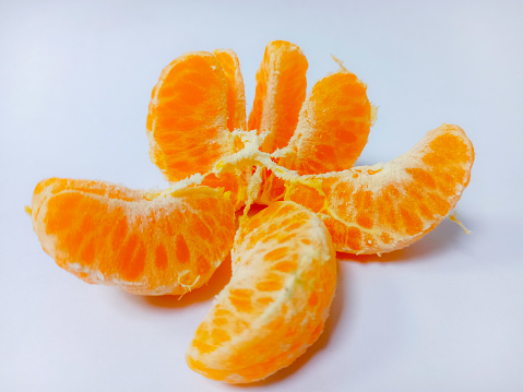 Tangerine or clementine slices isolated on a white background with full depth of field. Top view of Orange mandarin or tangerine fruit.