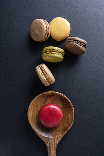 Various colorful macaroons in a wooden spoon