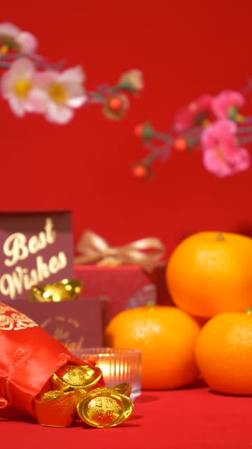 looping of Chinese Lunar New Year red background. ancient Chinese gold bar in silk bag, gift box with text best wishes, orange, paper fan, plum blossom, candle sway on Chinese new year celebrate