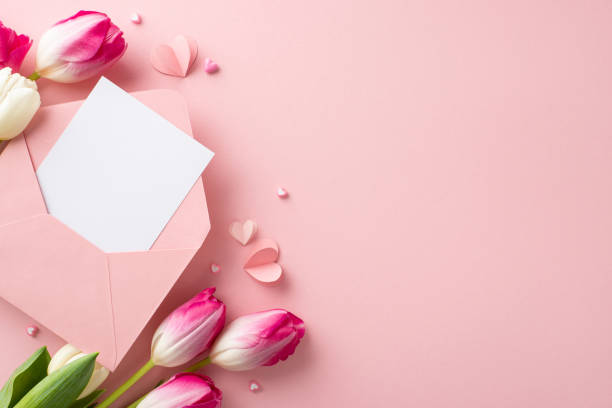 istock Love Blossoms: Shower your beloved with affection using top-view display of blooming tulips, heart-shaped ornaments, and handwritten invitation on pastel pink background. Ideal gesture for Woman's Day 1975265839