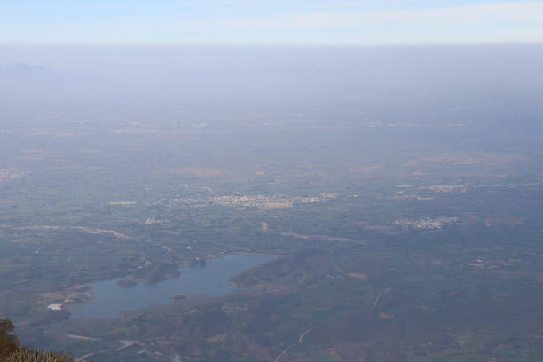 Clear view of blue sky, white clouds, mountains from the highest point of Mount Abu which is Guru Shikhar. A view of small villages from the the top