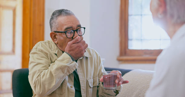 istock Senior, man and patient cough or nurse help for throat inflammation, infection or bacteria. Woman, male person and mouth hand for lung germs consultation or diagnosis symptoms, conversation or advice 1975299727