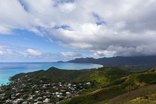 A Hawaiian coastline with light blue shores and cloudy mountains - O'ahu, Hawaii