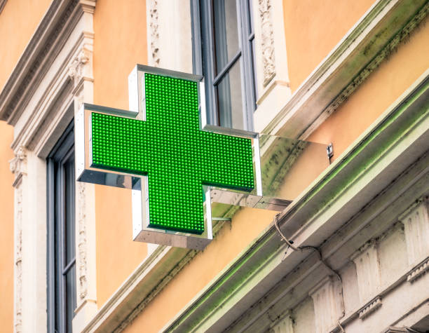 An electronic sign for a pharmacy on an external wall on a street in in central Rome, Italy.