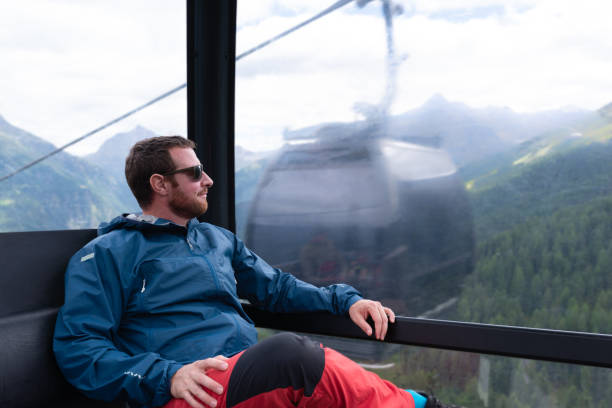 夏のスキー場でケーブルカーの車内を眺める男性。 - ötztal alps ストックフォトと画像