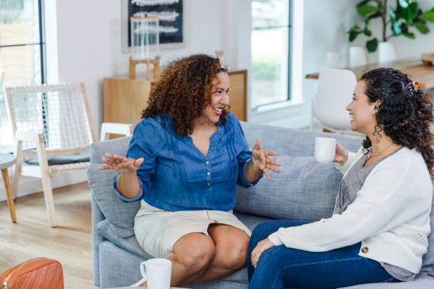 istock Mature female smiles and gestures while talking to her sister 1975342521