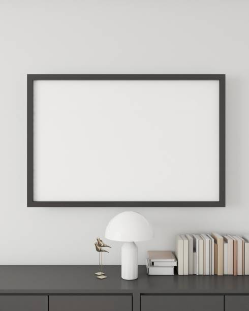 istock Minimalistic interior design featuring a modern sideboard with a framed blank poster, a stylish white mushroom lamp, and a neatly organized row of books, against a clean white wall. 3D render 1975351654