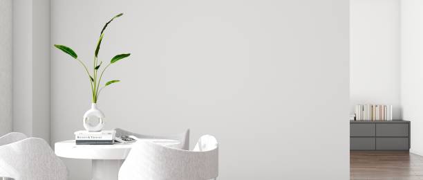 A bright and airy modern interior with a white round table, elegant grey upholstered chairs, and a chic vase with fresh green leaves, complemented by soft natural light, 3D render