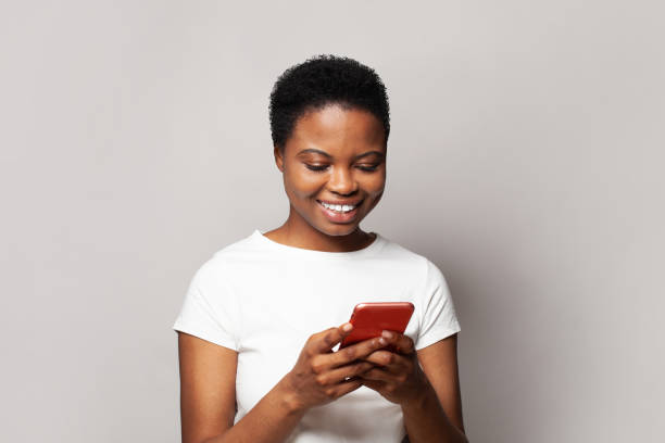 istock Pretty young woman texting on her phone. Happy casual model student using smartphone, messaging or browsing social networks 1975361081