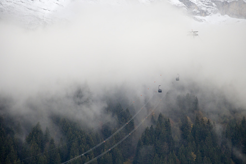 A dramatic picture of the Eiger express cable car entering a cloud