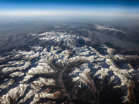 Aerial view of French Alps with Snow on the Mountains seen from Aircraft.