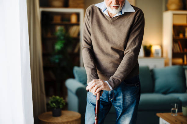 手、杖、障害のある高齢者、退職者のクローズアップ。高齢者介護、杖、バランスの補助、サポート、健康上の問題を伴う関節炎を伴うパーキンソン病 - human hand aging process senior adult cane ストックフォトと画像