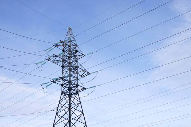 istock A high-voltage mast with wires on a background of blue sky with light clouds. Bottom view. 1975397038