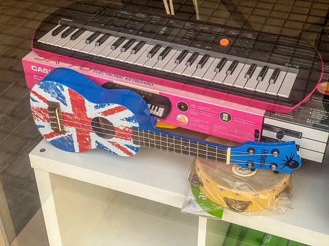 Valencia, Spain - January 27, 2024: High angle view of toy guitar with a British flag printed on it for sale in music store. This is a clear reference to the British rock and pop music, one of the most successful in the entire world