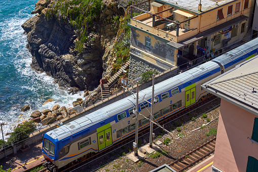 Train at the railway station in the mountains near the sea in the city of Riomaggiore, Italy. View from above