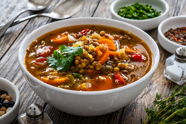istock Fresh vegetable soup with lentil on wooden table 1975440092